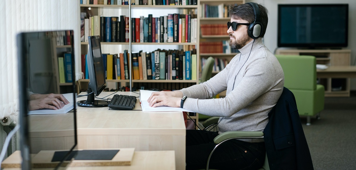 Fotografía de un hombre ciego trabajando con un ordenador