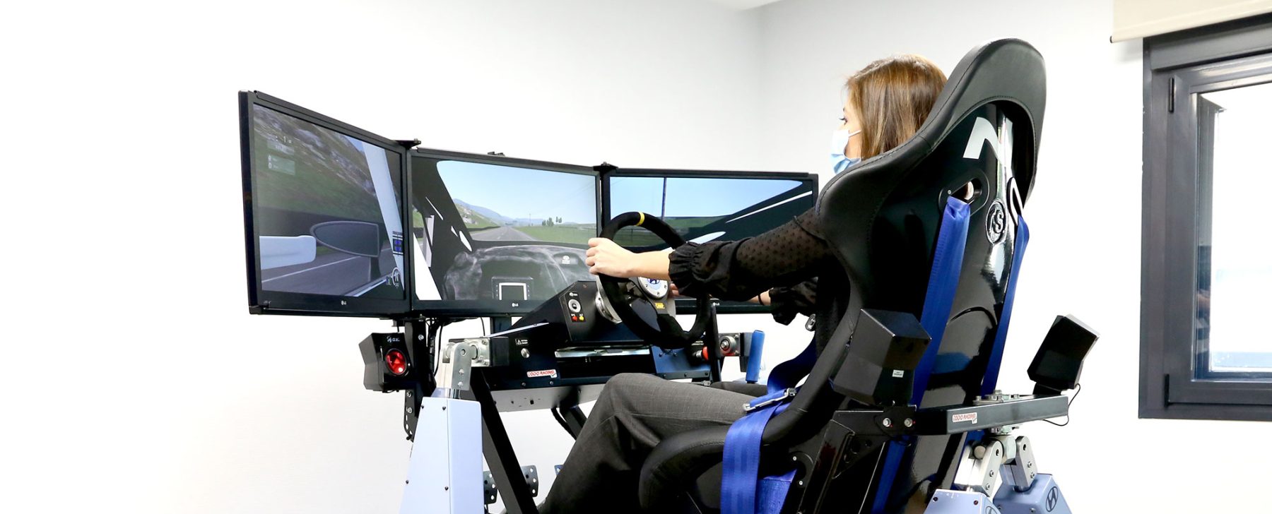 Fotografía de una mujer joven probando el simulador de conducción