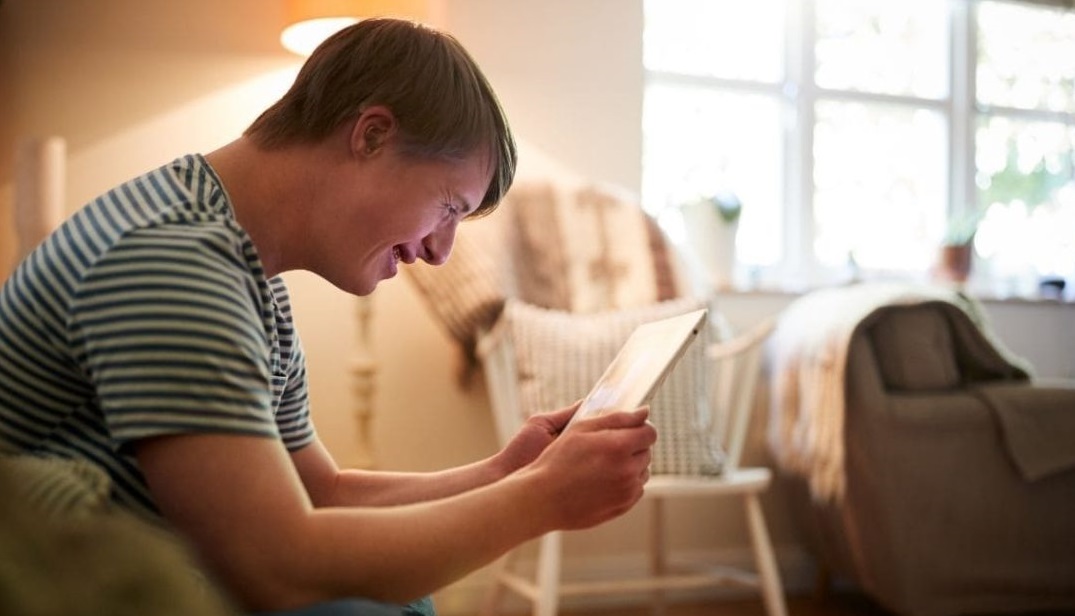 Hombre joven con Síndrome de Down utilizando un ipad