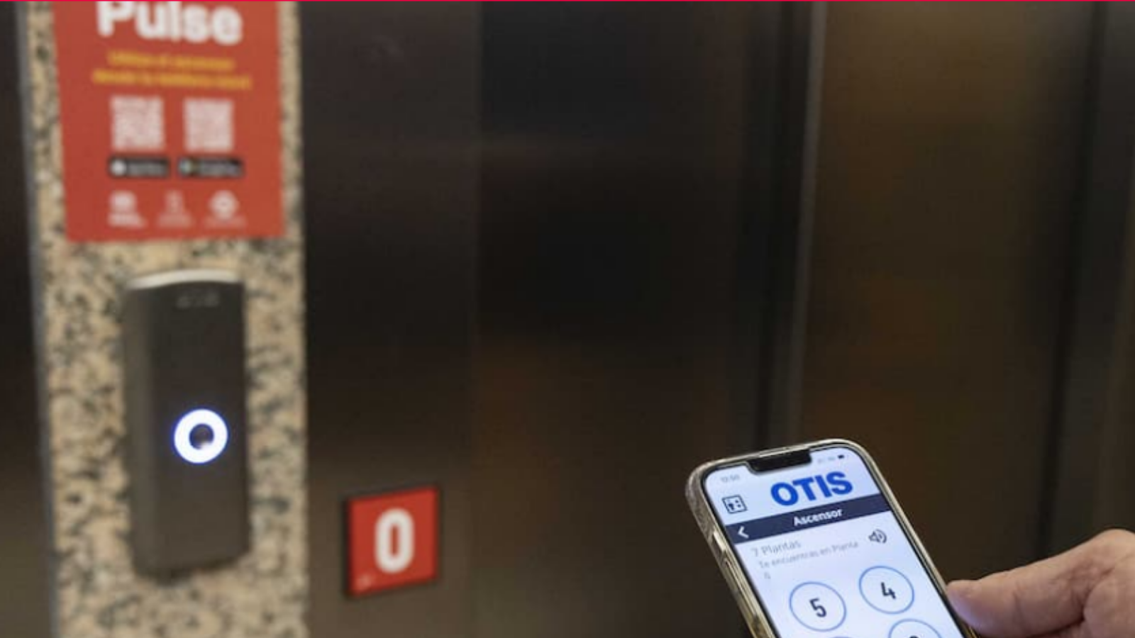 Imagen de un móvil con la aplicación Pulse y un ascensor al fondo