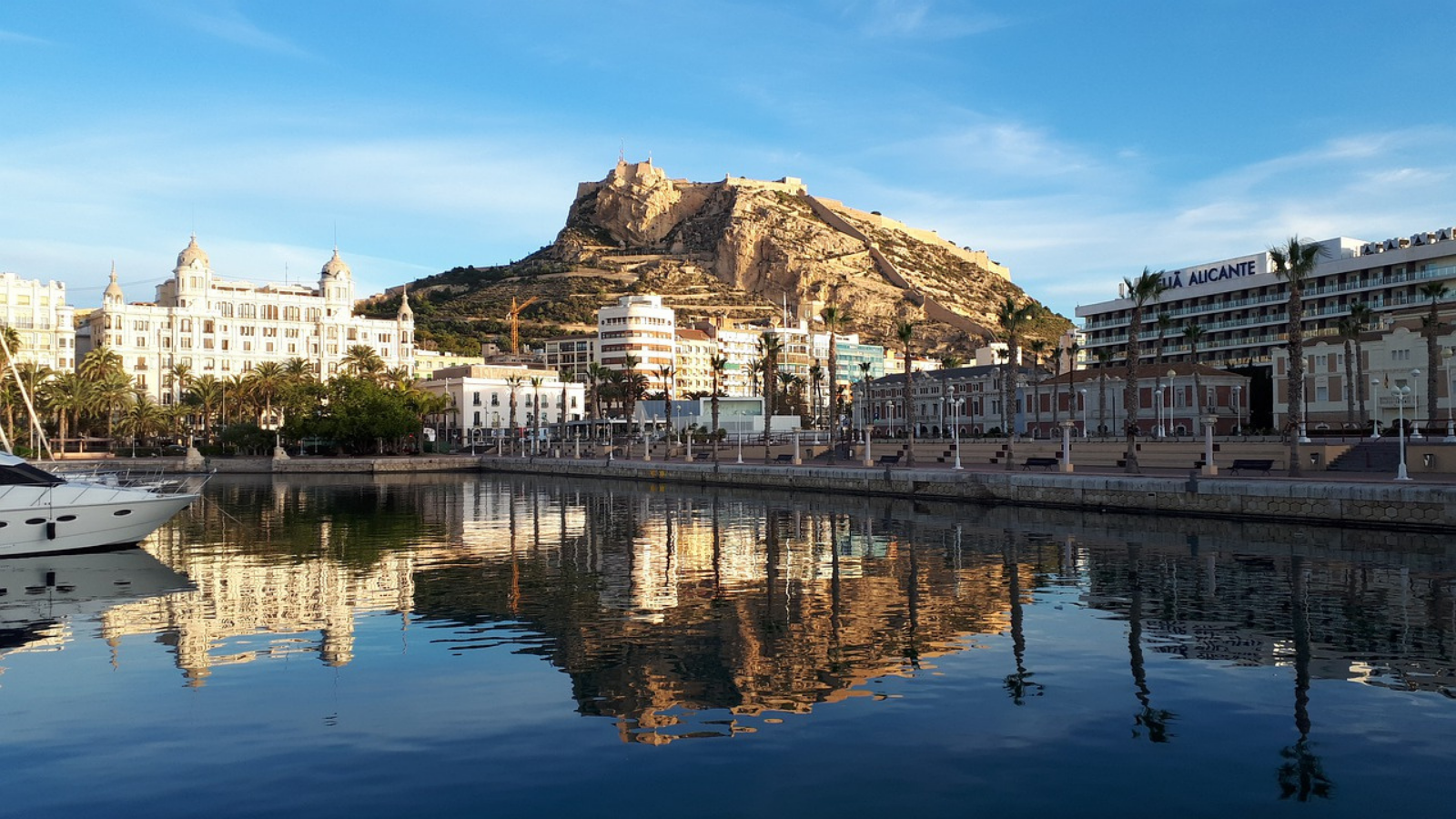 Fotografía de la ciudad de Alicante, con el mar, la línea de playa y el castillo al fondo