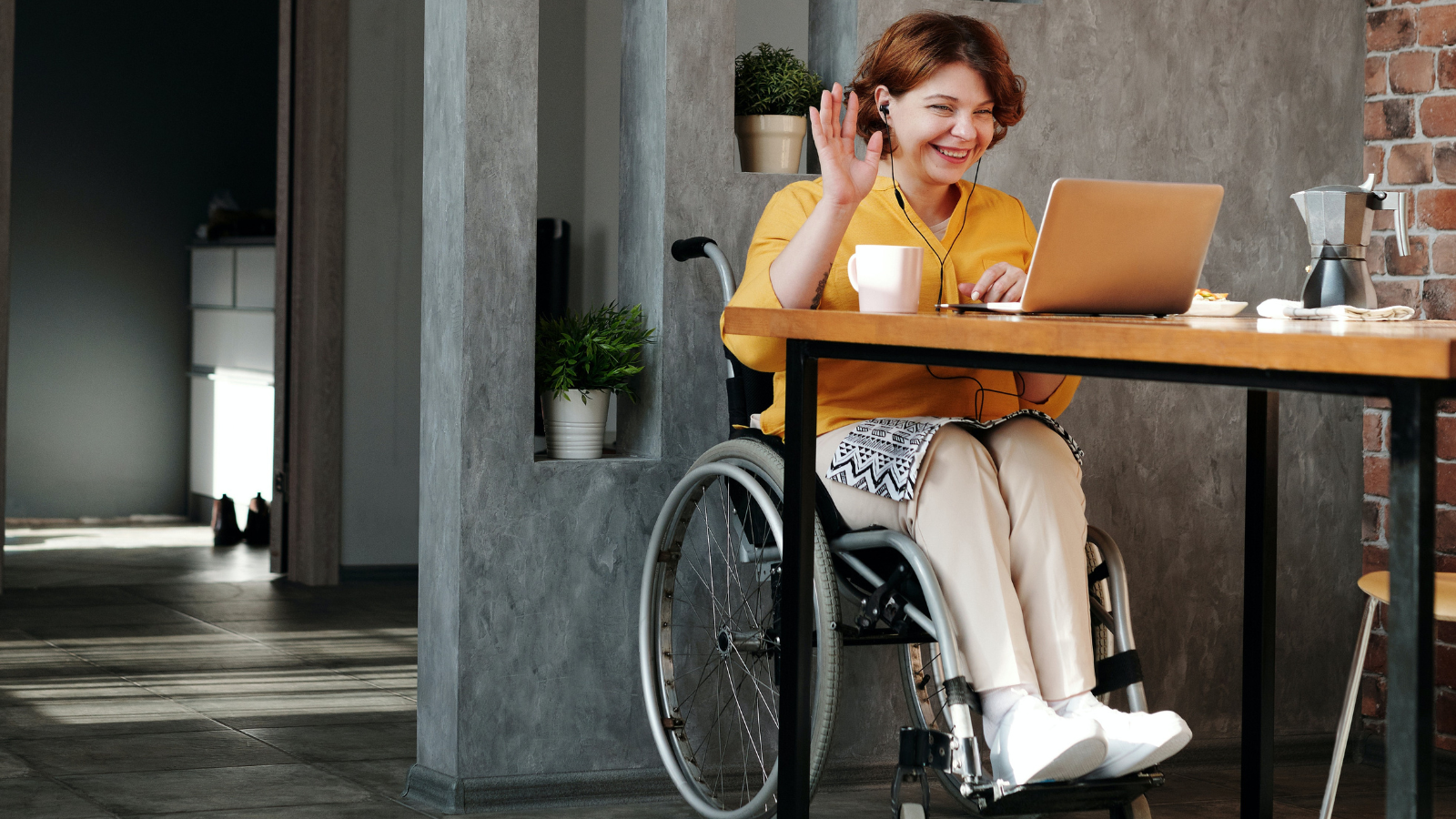 Fotografía de una mujer joven en silla de ruedas trabajando con su ordenador portátil